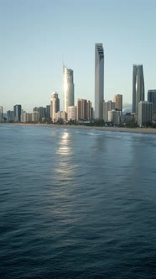Vertical drone flying backwards out to sea Surfers Paradise skyline Gold Coast ocean Queensland view