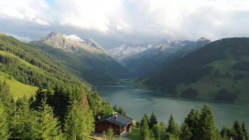 Aerial View of lake Speicher Durlassboden in Tirol, Austria with snowcapped mountains