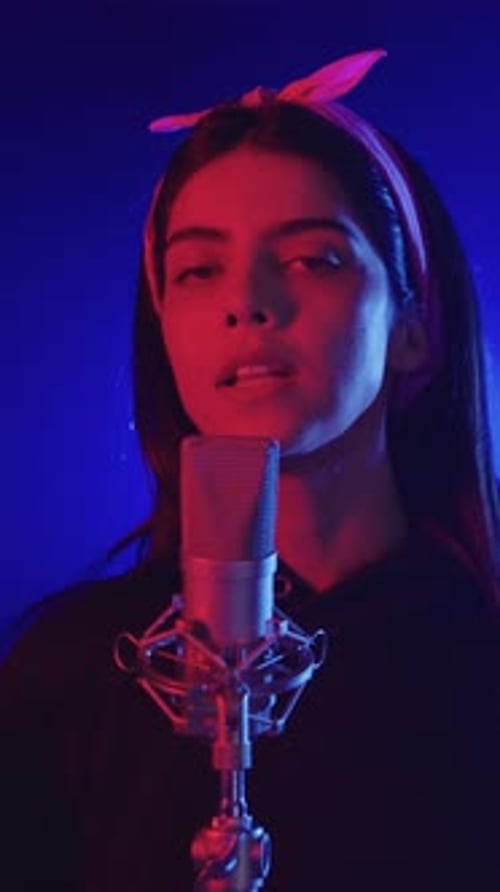 Young Singer Performing Song in Slow Motion with Blue and Red Lights