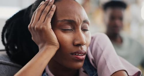 Thoughtful Woman Resting with Man in Background