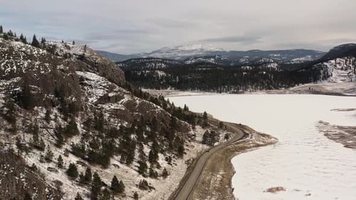 Awe-Inspiring Winter Scenery: Barnhartvale Road in Kamloops amidst Rolling Mountains and Snowy Terra