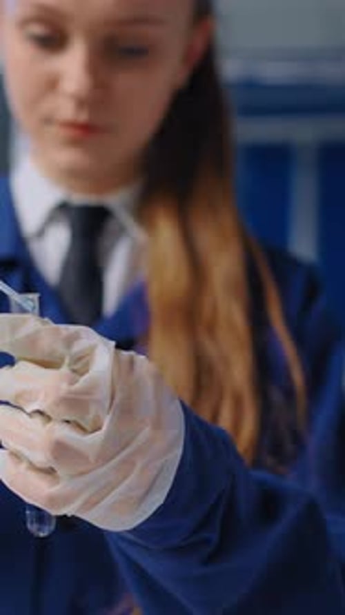 Focused Teen Examines Test Tube in Laboratory Setting