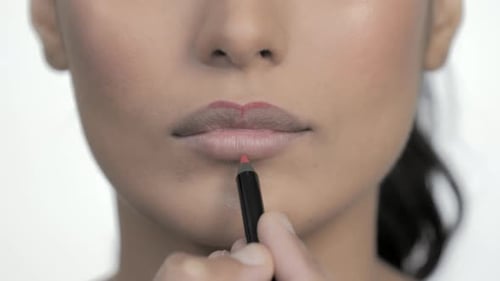Woman Applying Red Lip Liner Close Up