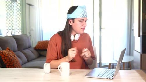 Young Adult Talking to Laptop in Bright Home Interior