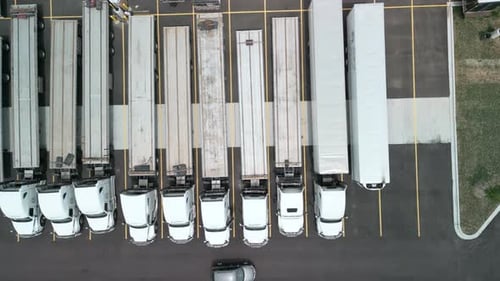 Parking of Logistics Warehouse with Semi Trucks and Cargo Trailers Aerial Above View