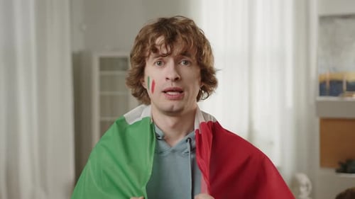 Excited Man Celebrates Victory with Flag and Painted Face