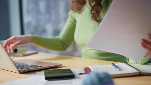 Businesswoman Working at Desk Analyzing Documents