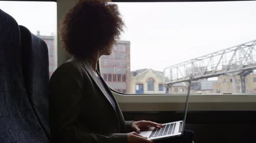 Woman Working on Laptop During Train Commute