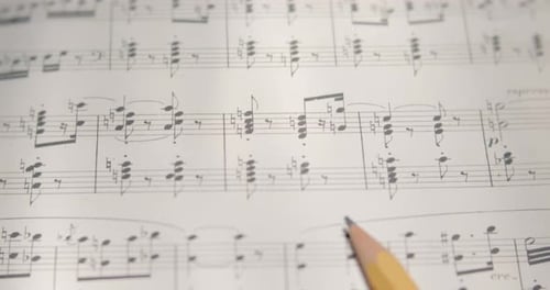 View over musical notes and pencil