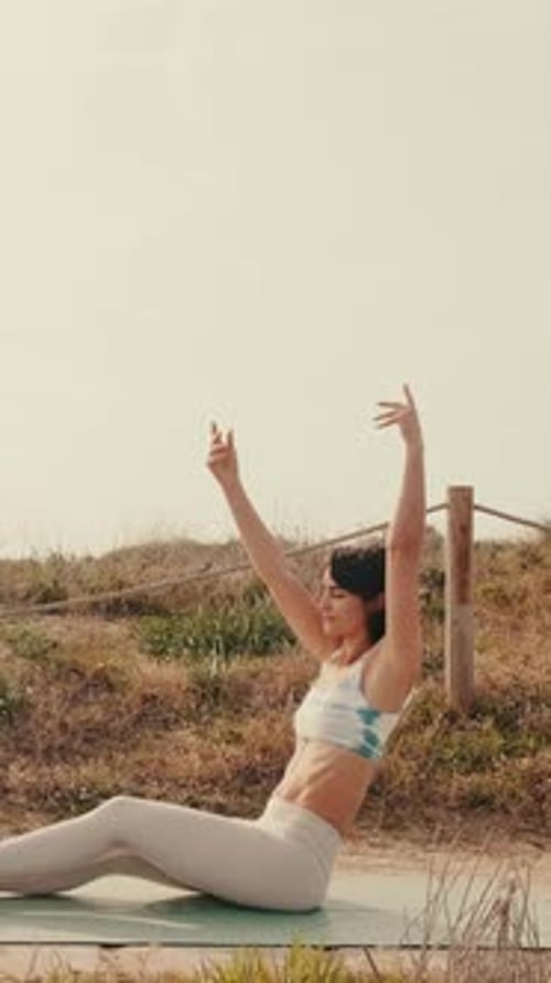 Woman Practices Yoga at the Beach