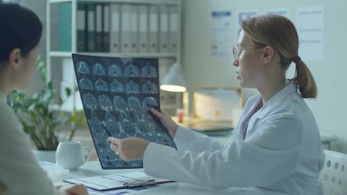 Doctor Explains X-Ray to Patient in Office