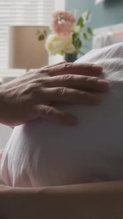 Vertical de la main du mari caressant tendrement le ventre de la femme enceinte
