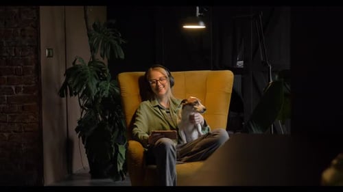 Woman Relaxing in Armchair with Dog and Tablet