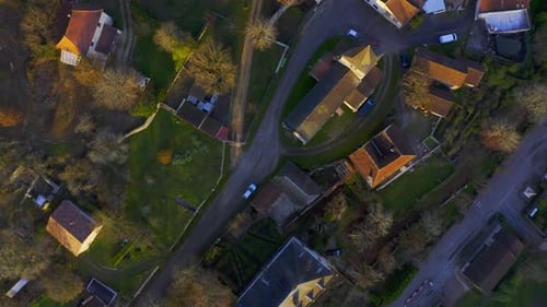 Drone filmé au-dessus d'un petit village français au coucher du soleil. Une église est située au centre de la ville