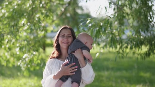 Loving Mother Holding Baby in a Green Park