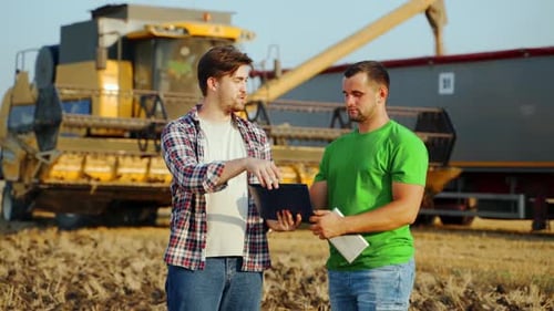 Un agente de logística agrícola firma un acuerdo sobre el suministro de granos, se da la mano en un campo de trigo y un agrónomo discute