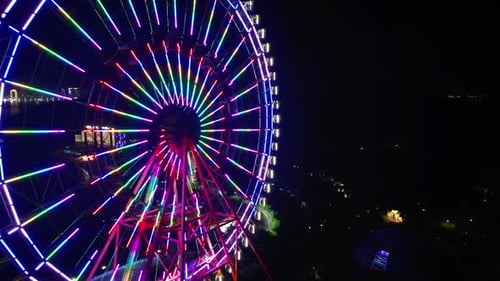 Luftbild von oben auf das Riesenrad im Vergnügungspark bei Nacht, Riesenradbeleuchtung am Abend