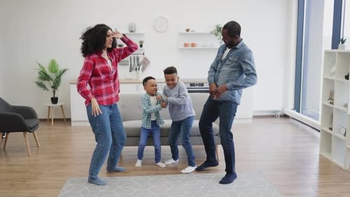 Happy Family Dancing Together in Modern Home