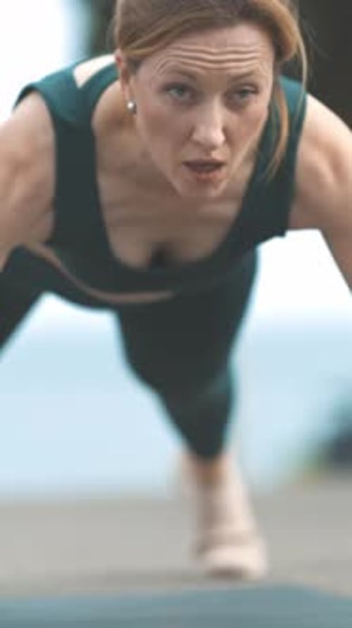 Woman Doing Pushups on Yoga Mat Outside