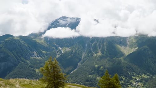 Timelapse with clouds covered the mountain in gray summer day. Alpine scenery with mountain peak