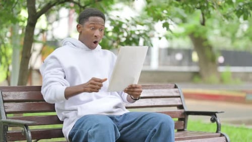 Young Man Receives Good News in the Park
