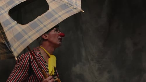 Clown Peeking Around Umbrella in Costume and Makeup
