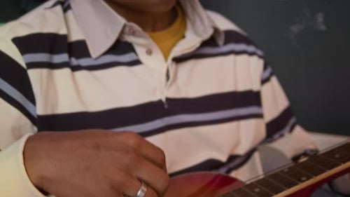 Teen Plays Acoustic Guitar in Room
