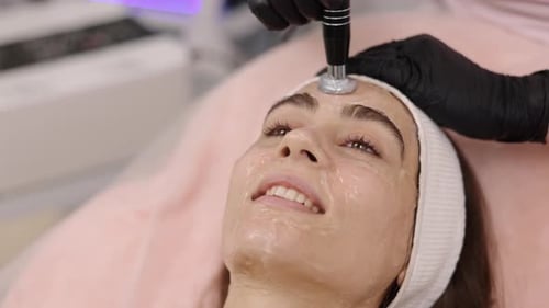 Woman Receiving a Facial Treatment in Clinic