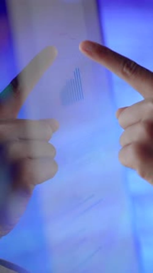 Hands Directing Attention Towards a Financial Chart Displayed on a Digital Screen Surface