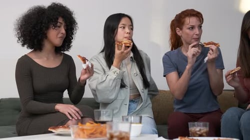 Young Women Enjoying Pizza and Friendship at Home