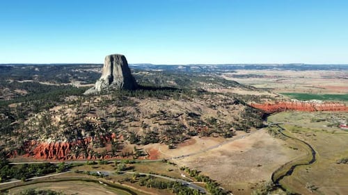 Aerial drone view of Devils Tower National Monument rising dramatically above the surrounding landsc