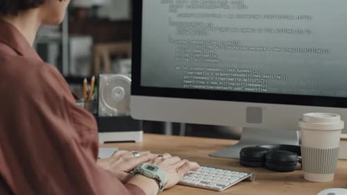 Femme spécialiste informatique écrivant des codes sur un ordinateur