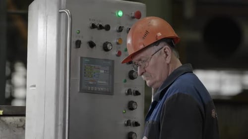 Man Works Factory Control Panel Machine