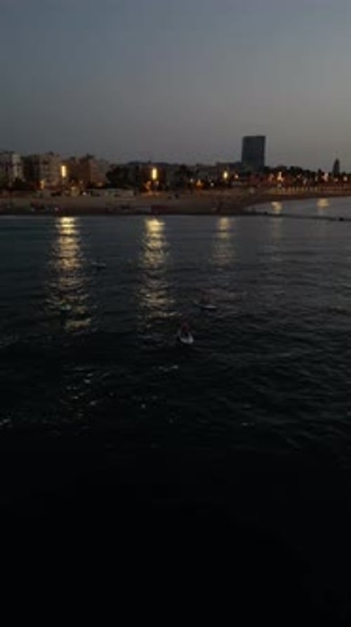 Aerial video on Barcelona's coastline people doing a sap.