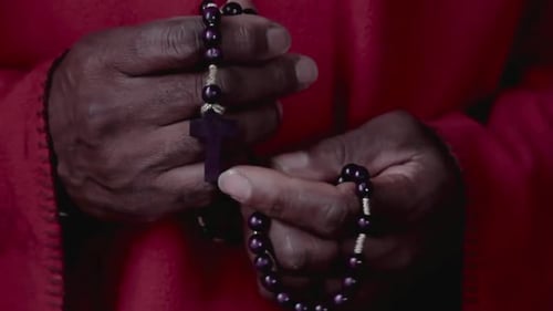 Hands Holding and Praying with Rosary Beads