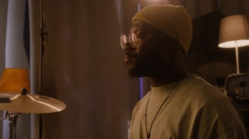Black Male Musician Performing on Drumkit while Recording in Studio