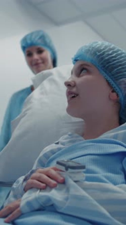 Girl Lies on Gurney and Shows Pulse Oximeter to Medic