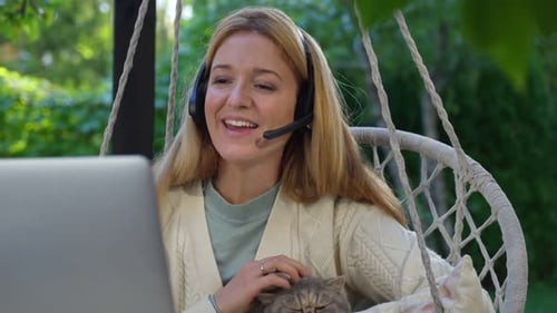 Woman with Cat Working Remotely Using Laptop Outdoors