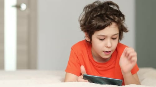 Primary School Boy Plays on the Phone