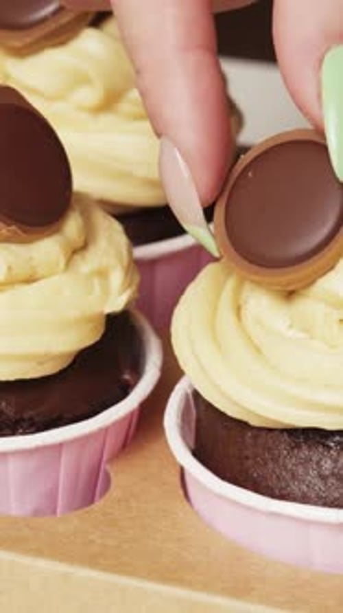 Decorate chocolate cupcakes with mini cookies and toffees Vertical video.