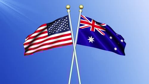 United States and Australia National Flags Waving Against Blue Sky