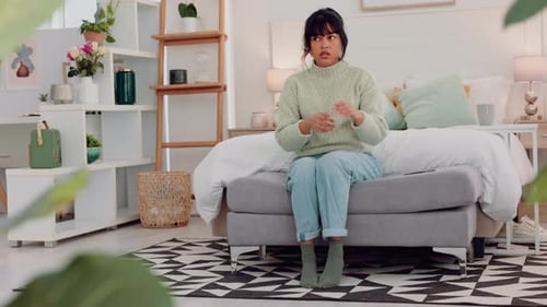 Worried Woman Sitting On Bench In Bedroom