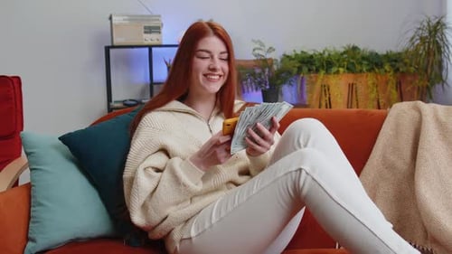 Woman Using Phone, Holding Currency in Home