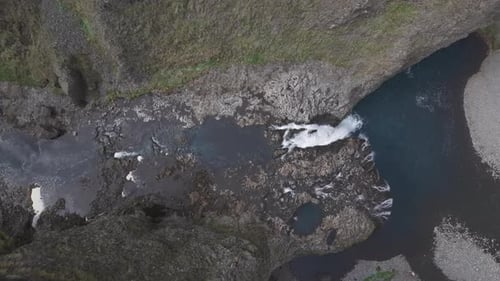 Aerial view of people jumping at Stjornarfoss waterfall, Iceland