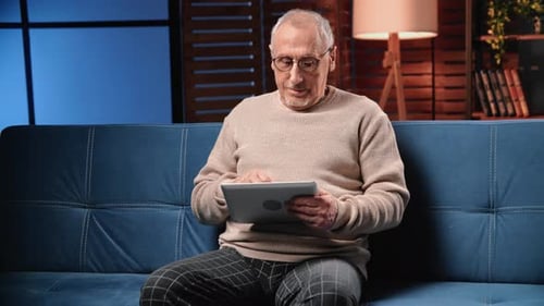 Man Using Tablet While Relaxing on Couch