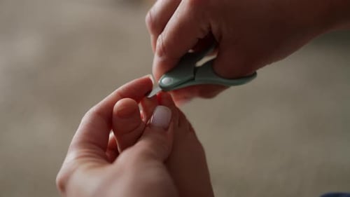 Woman Trims Child's Toenails With Clippers