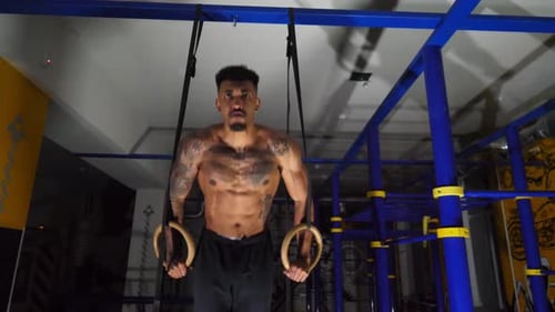 Muscular Afro American Sportsman Doing Push Ups on Gymnastic Rings at Gym Strong African Athlete