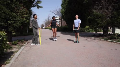 Three Friends Exercising Outdoors with Resistance Bands