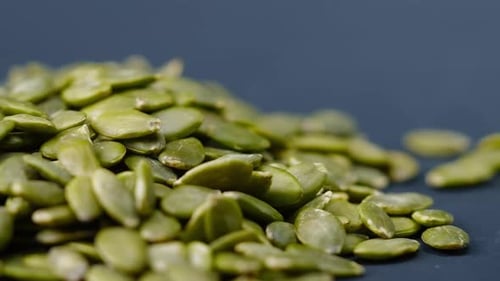 Closeup on Blackblue Background Lie Green Pumpkin Peeled Seeds Healthy Eating Autumn Harvest Healthy