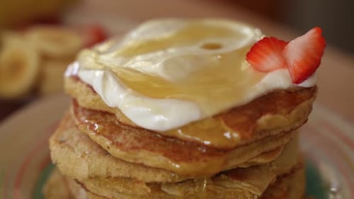 Fresh Strawberries Fall on Top of Stack of Homemade Pancakes, Slow Motion Close Up